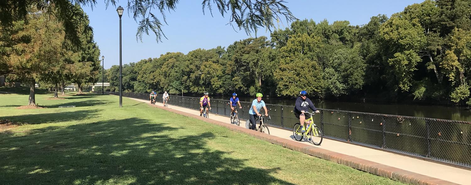 A group of cyclists ride on a trail