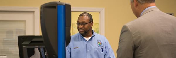 NCDMV Employee at a counter with customer.